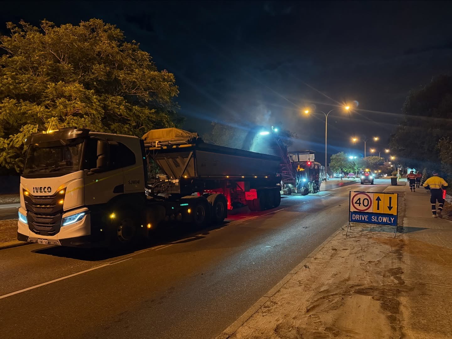 SuperCivil night profiling operation with cold milling machine and tipper truck on a Western Australian road