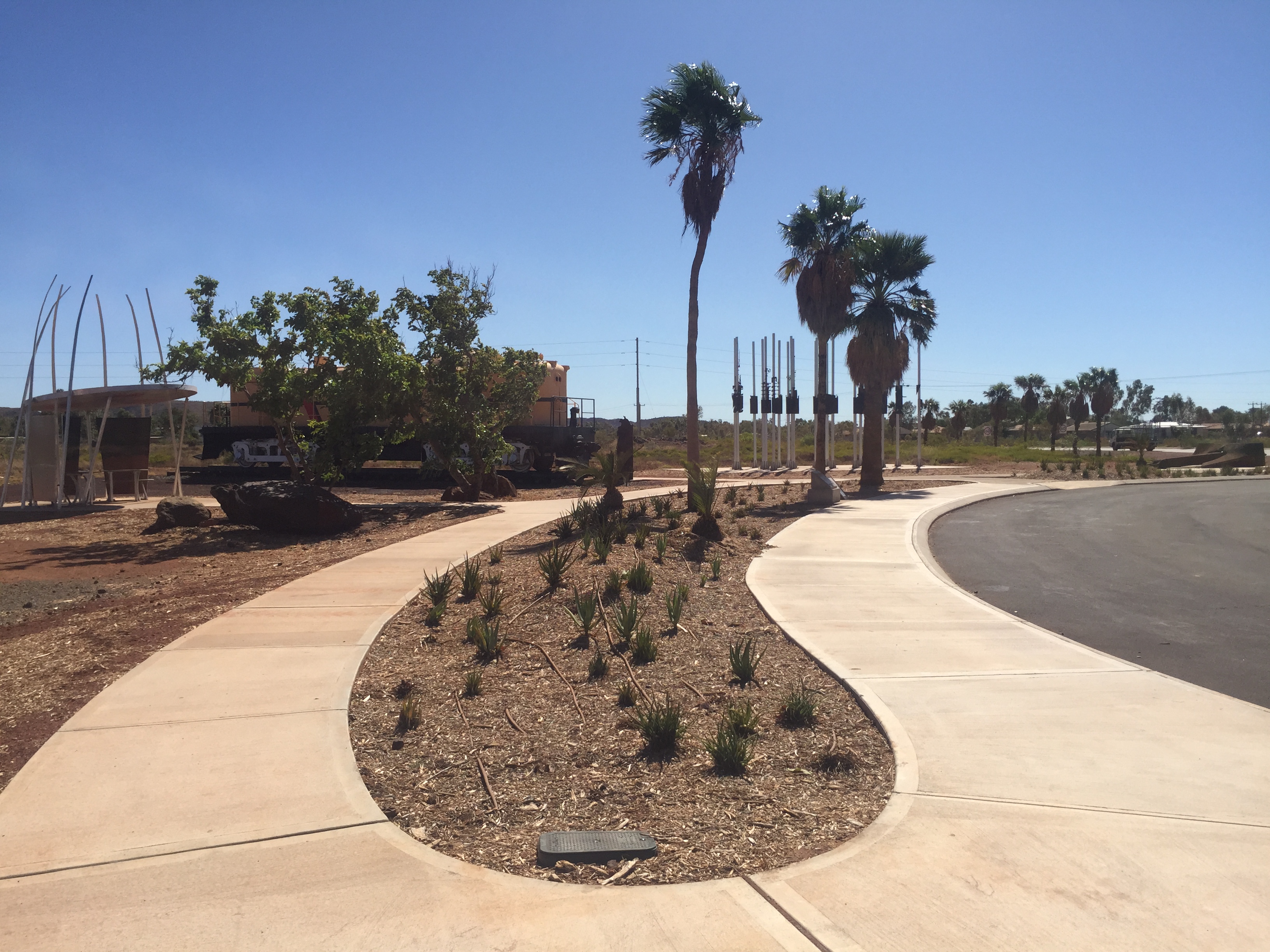 Curved decorative concrete footpaths winding through landscaped garden beds on a completed SuperCivil public realm project in regional Western Australia