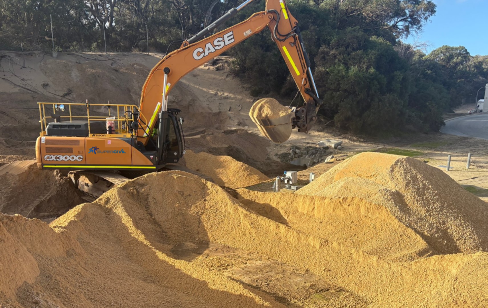 SuperCivil-branded CASE CX300C tracked excavator moving sandy fill material with large mounds on a Western Australian earthworks site