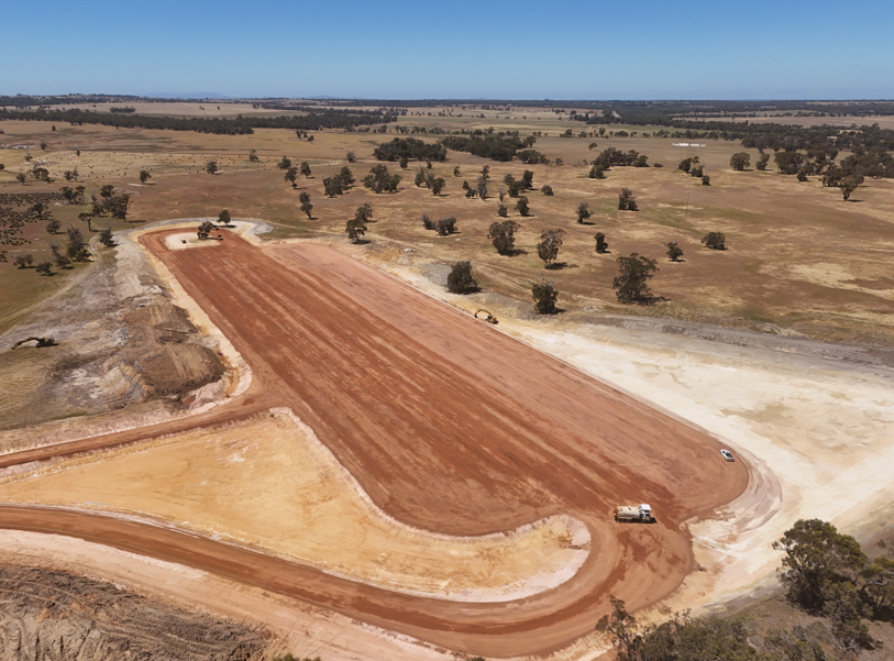 Aerial view of a large graded and compacted earthworks formation with shaped edges and haul roads on a rural Western Australian civil construction site